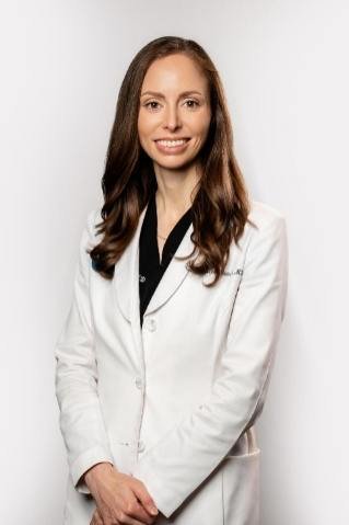 Dr. Madeleine Sowash, board-certified dermatologist, in a white coat